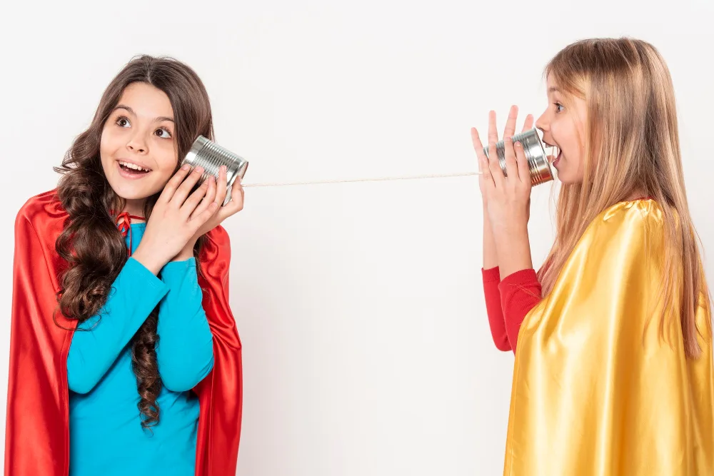 Manfaat Bermain Peran atau Roleplay untuk Belajar Bahasa Inggris 1 Roleplay image. 2 Anak perempuan yang menggunakan baju superhero dan mengobrol.
